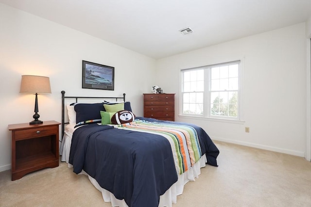 bedroom featuring baseboards, visible vents, and light carpet