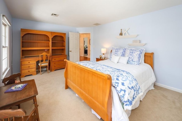 bedroom featuring light carpet, visible vents, multiple windows, and baseboards