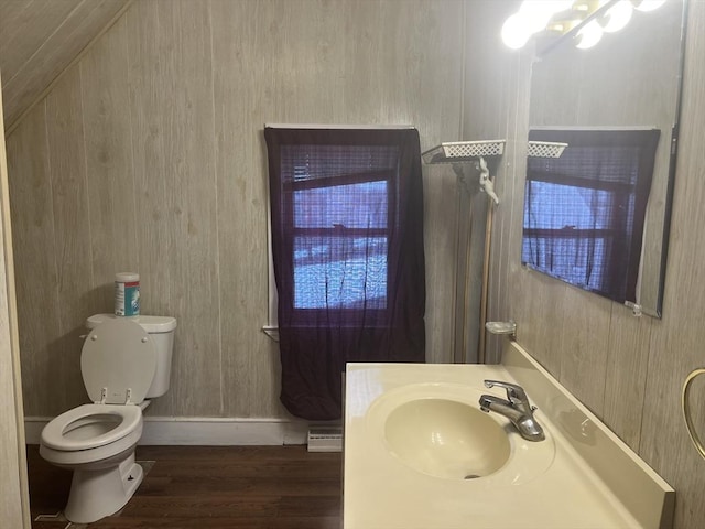 bathroom with baseboards, a shower, toilet, a baseboard radiator, and wood finished floors