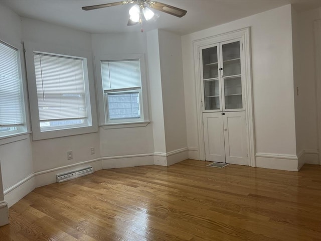 spare room with baseboards, visible vents, and light wood finished floors