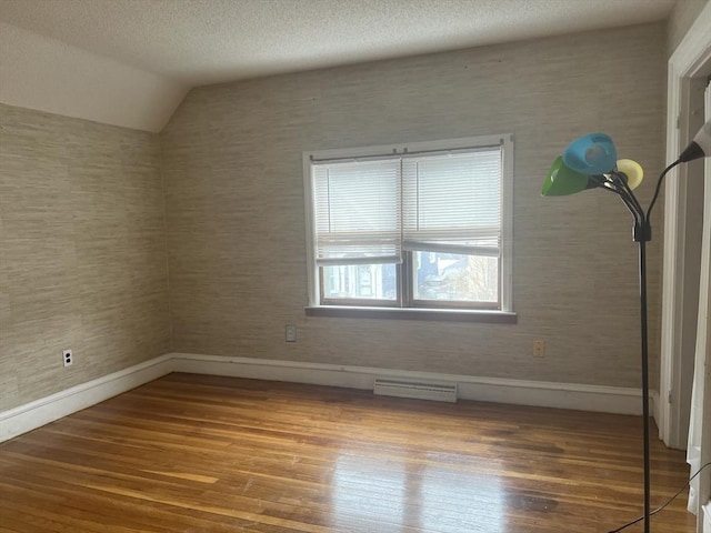 interior space featuring baseboards, a textured ceiling, visible vents, and wood finished floors