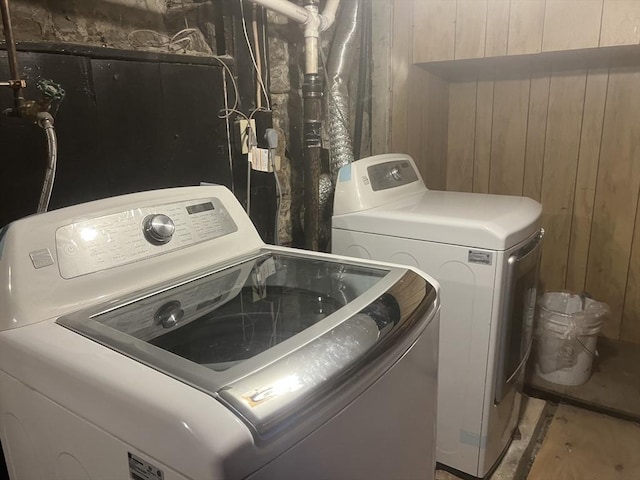 laundry room with independent washer and dryer and wooden walls