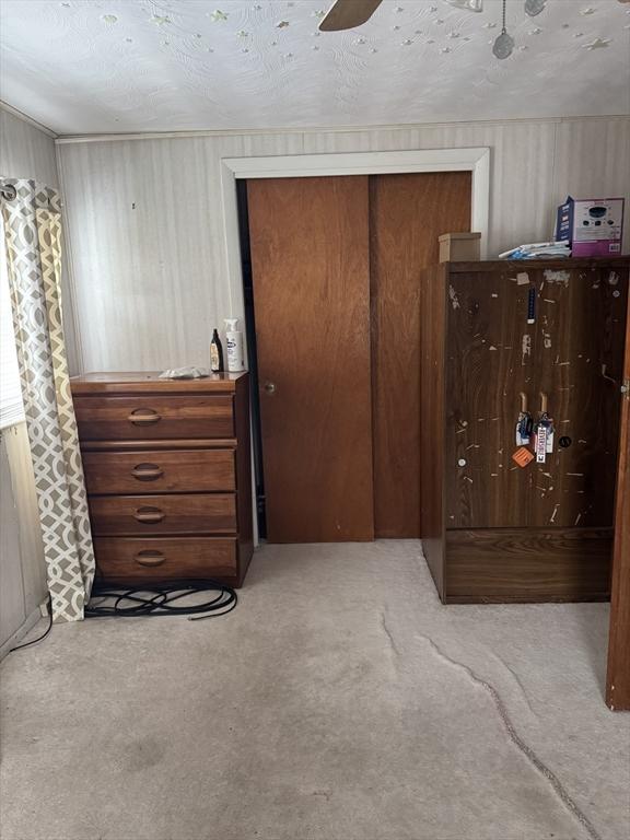 bedroom with ceiling fan, a closet, and light carpet