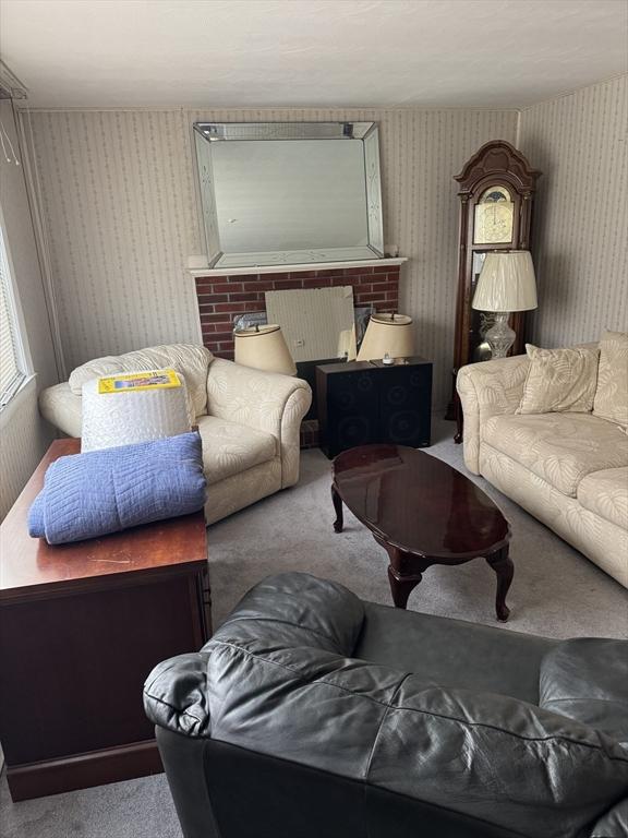 living room with radiator, a fireplace, and carpet