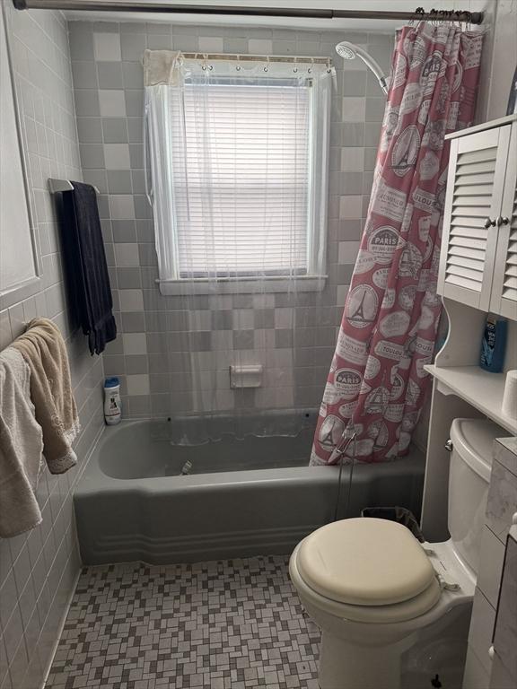 bathroom featuring shower / bath combo and toilet