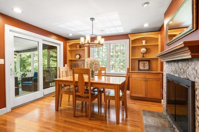 141 Morse Rd, Sudbury, MA 01776 - dining room with a chandelier, light wood finished floors, and a fireplace with flush hearth
