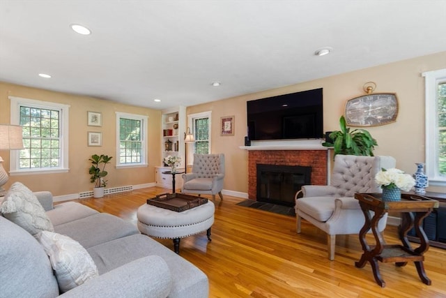 141 Morse Rd, Sudbury, MA 01776 - living room featuring light wood finished floors, plenty of natural light, a fireplace, recessed lighting, and a baseboard heating unit