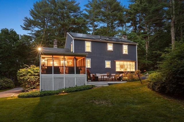141 Morse Rd, Sudbury, MA 01776 - back of property with a chimney, a lawn, and roof mounted solar panels