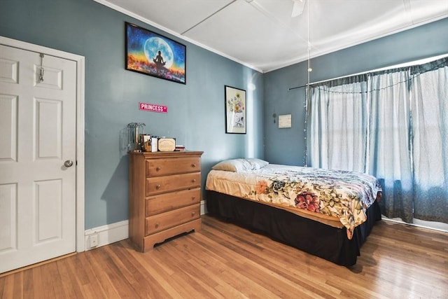 bedroom with hardwood / wood-style flooring, ceiling fan, and ornamental molding