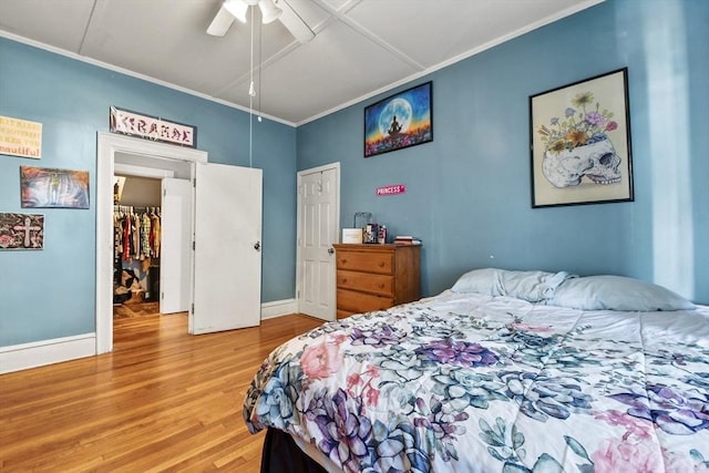 bedroom with hardwood / wood-style flooring, ceiling fan, and ornamental molding