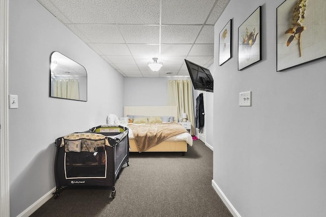 carpeted bedroom featuring a drop ceiling