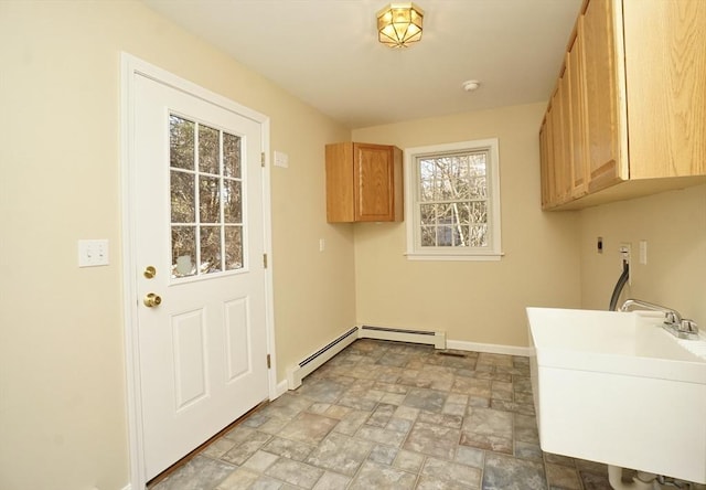 clothes washing area with sink, cabinets, a healthy amount of sunlight, and washer hookup