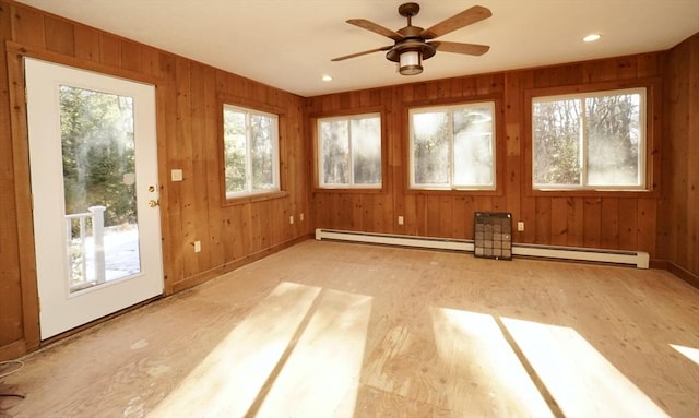 unfurnished sunroom with a baseboard radiator and ceiling fan