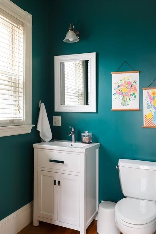 bathroom featuring vanity, a healthy amount of sunlight, and toilet