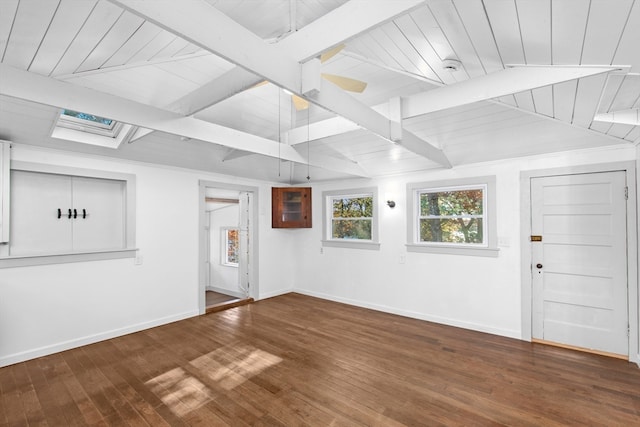 interior space featuring beam ceiling, a skylight, hardwood / wood-style flooring, and wooden ceiling