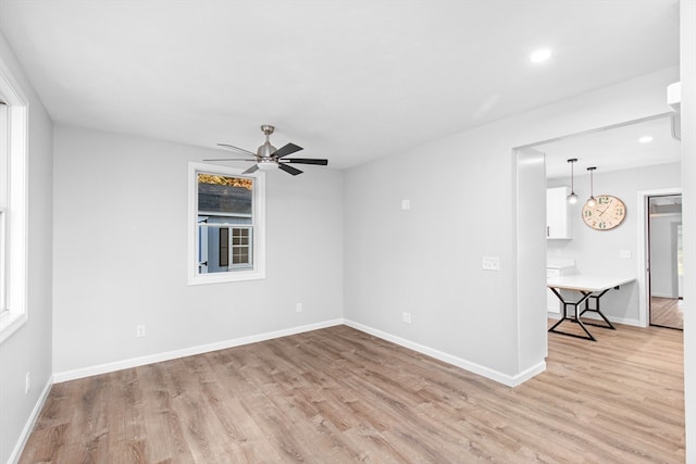 empty room with light hardwood / wood-style floors, a wealth of natural light, and ceiling fan