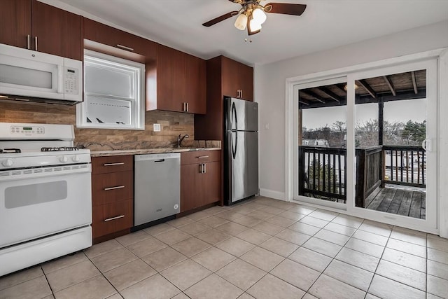 kitchen with light stone counters, stainless steel appliances, light tile patterned floors, backsplash, and ceiling fan