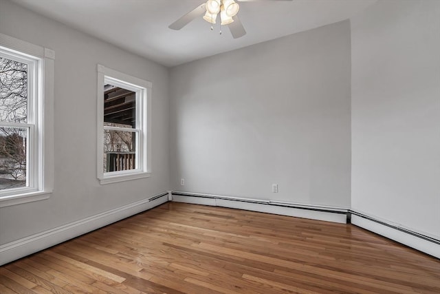 empty room with light hardwood / wood-style flooring, a baseboard heating unit, and ceiling fan