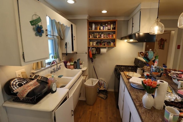 kitchen featuring white cabinetry, black gas stove, sink, and pendant lighting