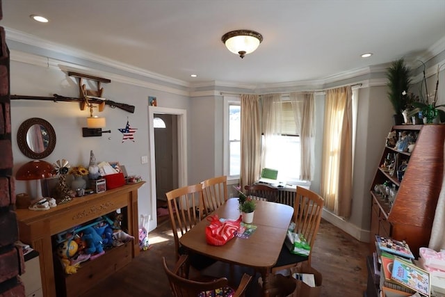 dining area with ornamental molding and dark hardwood / wood-style floors