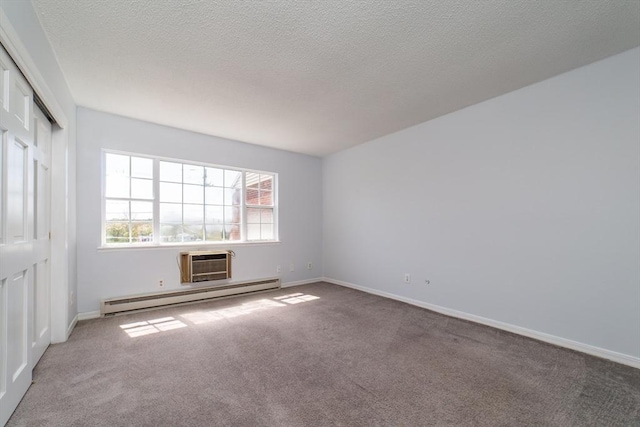 empty room with baseboards, a wall mounted AC, baseboard heating, and carpet floors