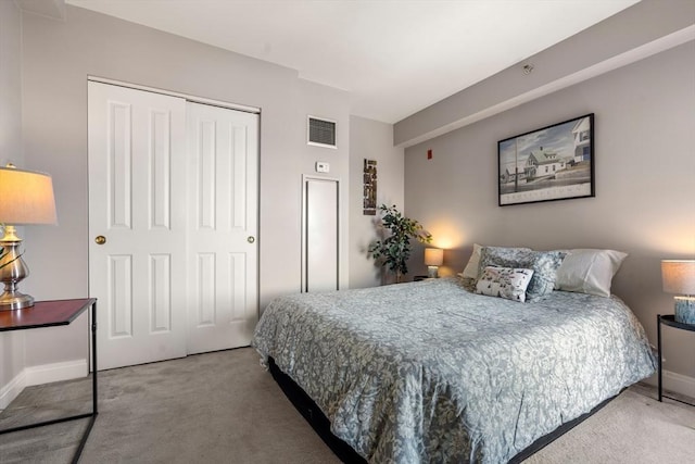 bedroom featuring baseboards, a closet, visible vents, and carpet
