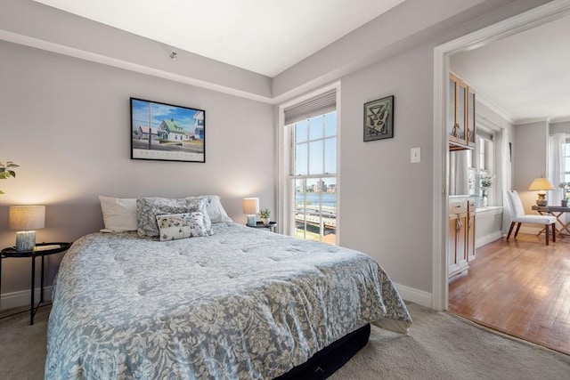 carpeted bedroom featuring baseboards and multiple windows