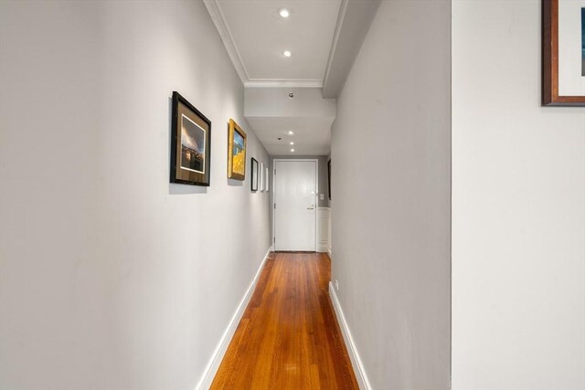 hall featuring crown molding, wood finished floors, baseboards, and recessed lighting