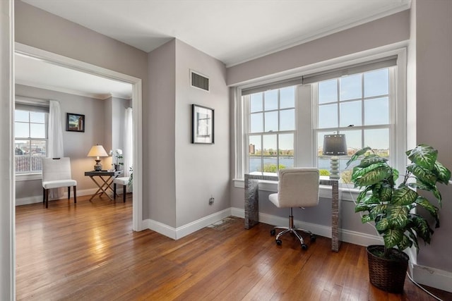 office with crown molding, hardwood / wood-style flooring, baseboards, and visible vents