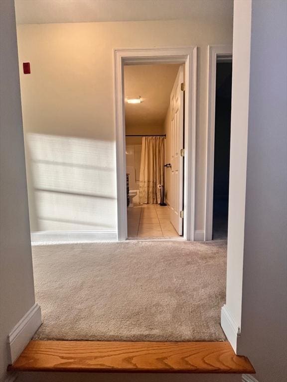 hallway featuring light colored carpet