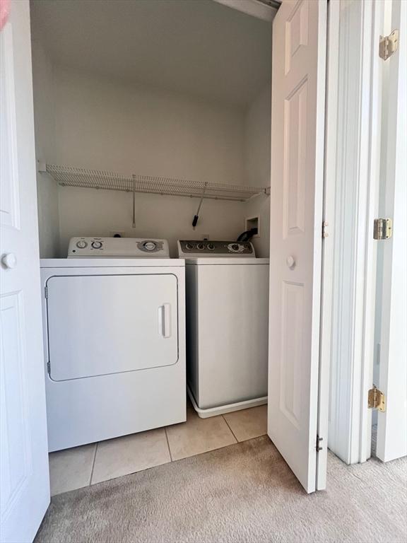 laundry room featuring washer and dryer and light tile patterned floors