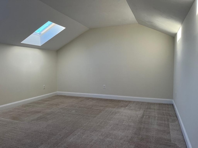 additional living space with carpet floors and vaulted ceiling with skylight