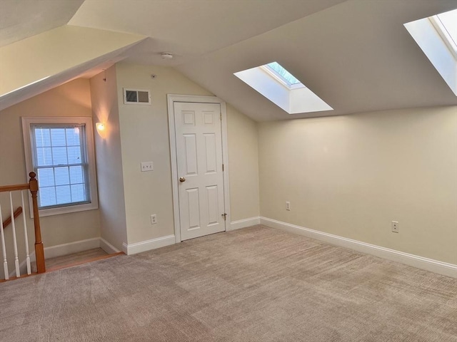 additional living space featuring vaulted ceiling and light carpet