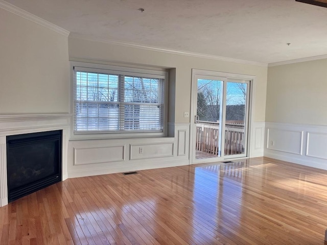 unfurnished living room with ornamental molding and light hardwood / wood-style floors