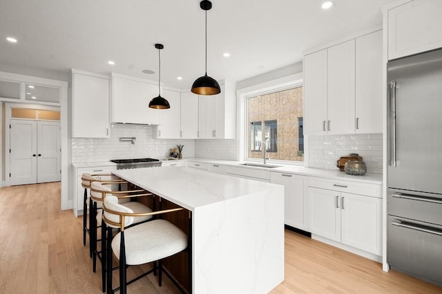 50 Hamilton Rd, Belmont, MA 02478 - kitchen with stainless steel built in refrigerator, a sink, light wood-type flooring, backsplash, and recessed lighting