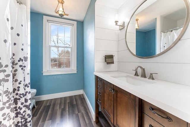 bathroom featuring wood-type flooring, toilet, and vanity