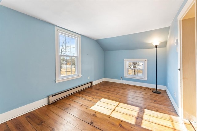 bonus room with baseboard heating, a healthy amount of sunlight, vaulted ceiling, and light wood-type flooring