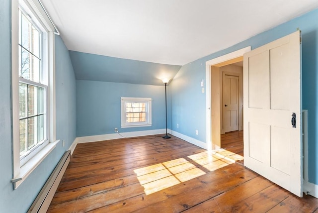 additional living space featuring a baseboard radiator, lofted ceiling, and hardwood / wood-style floors