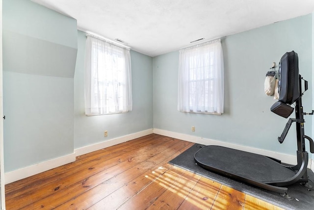 exercise room with hardwood / wood-style flooring and a healthy amount of sunlight