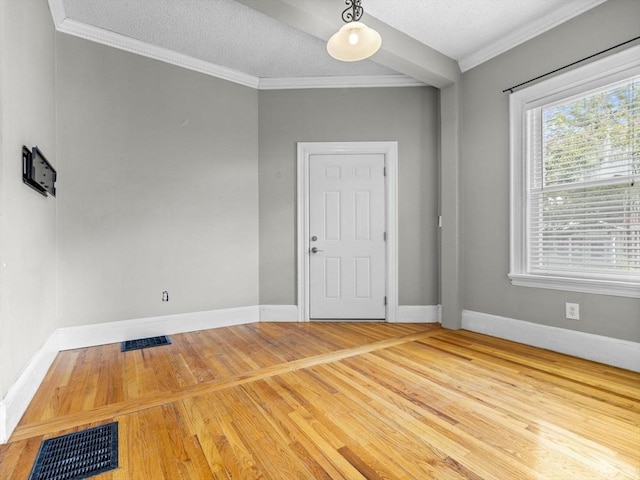 spare room featuring a textured ceiling and crown molding