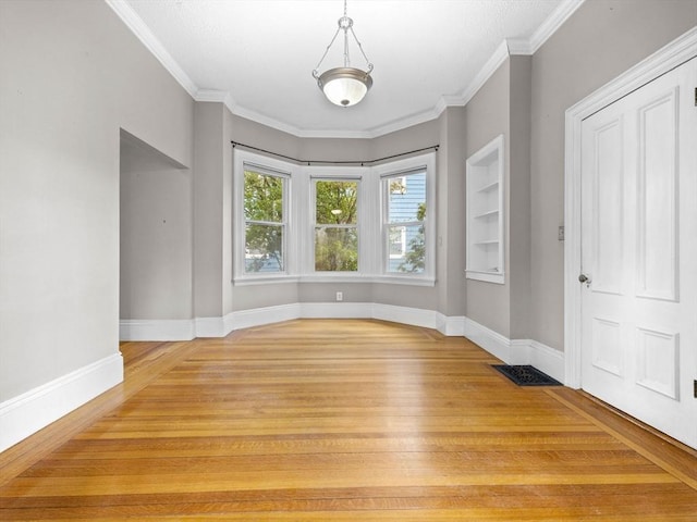 interior space with built in features, crown molding, and wood-type flooring