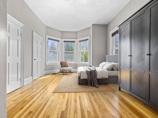 living area featuring light wood-type flooring and a textured ceiling