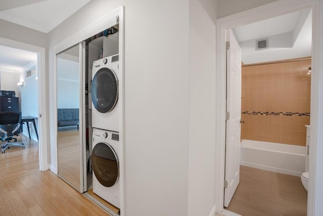 566 Commonwealth Ave Unit 906, Boston, MA 02215 - washroom featuring estacked washer and dryer, light wood-type flooring, and a desk