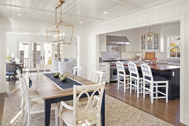 dining room with a notable chandelier, ornamental molding, dark wood-type flooring, and french doors