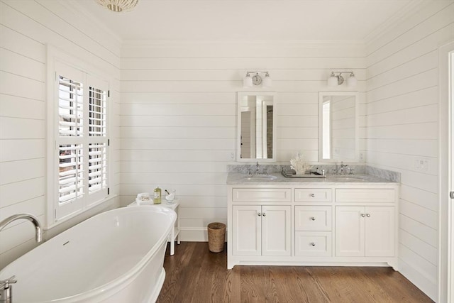 bathroom with a washtub, a healthy amount of sunlight, wood-type flooring, and vanity