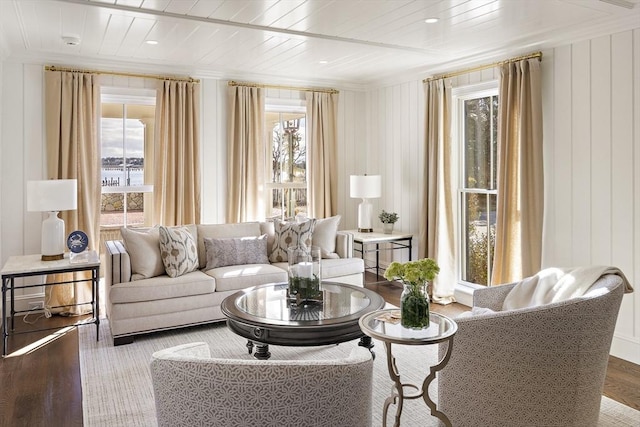 living room featuring hardwood / wood-style flooring, plenty of natural light, wood ceiling, and crown molding