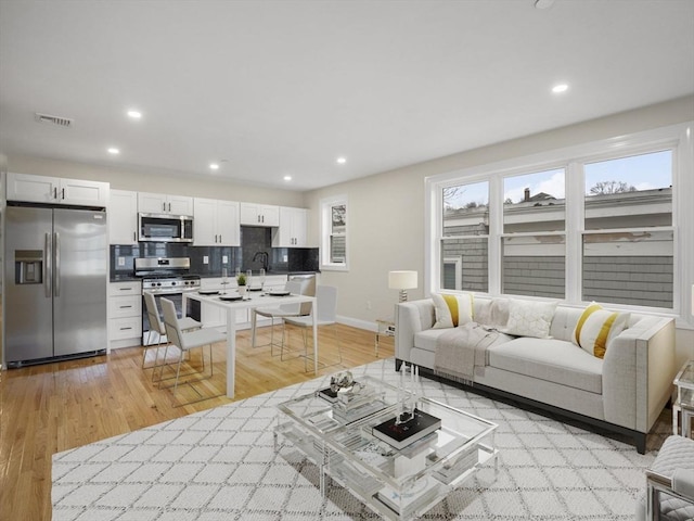 living room featuring sink and light wood-type flooring