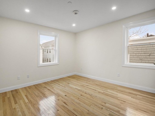 unfurnished room featuring light wood-type flooring and a wealth of natural light