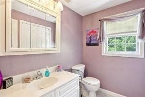 84 E Ave, Lowell, MA 01854 - bathroom featuring vanity, toilet, and baseboards
