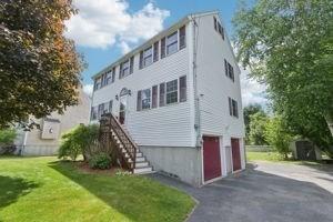 84 E Ave, Lowell, MA 01854 - rear view of property with an attached garage, a lawn, asphalt driveway, and stairway